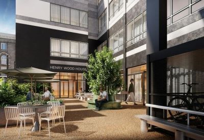 Outdoor courtyard with patio seating, lush greenery, and a bicycle storage rack.