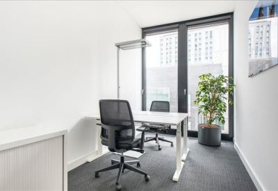 Private office with two desks, ergonomic chairs, and large window.