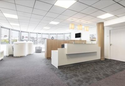Spacious reception area with a modern white desk and stylish overhead lighting.