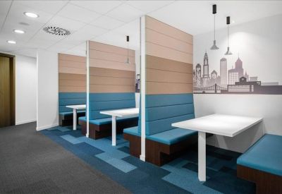 Breakout area with teal booth seating and a skyline wall mural.