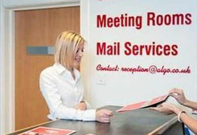 Receptionist at a front desk assisting a guest with paperwork.