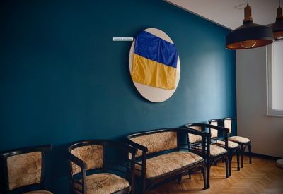 Waiting area with vintage-style chairs and a blue feature wall displaying a flag.