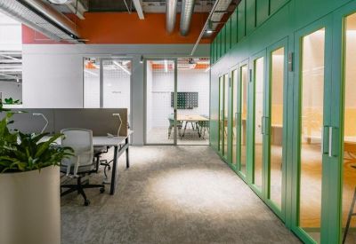 Vibrant corridor featuring a row of green-framed glass phone booths and an orange accent wall.