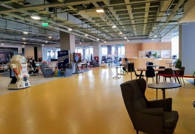 Wide view of a yellow-floored lounge and reception area with comfortable armchairs.