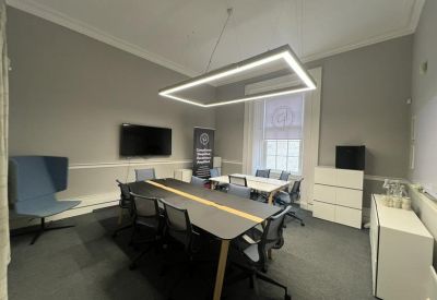 Meeting room with a large table and a wall-mounted TV.