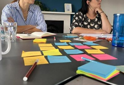 Team collaboration area with colorful sticky notes on the table and blue feature wall.