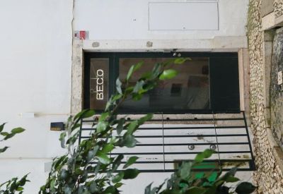 Building entrance at 2B, Beco do Rosendo, Lisbon with a dark door and metal security gate.