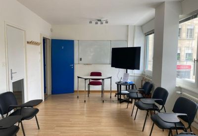 Classroom or meeting room at 3, Rue de Cornavin with a whiteboard, presentation screen, and rows of seating.
