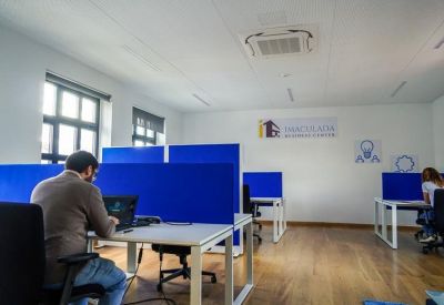 Open-plan workspace with blue privacy screens and desks at 45, Rua do Comércio, Vilar Formoso.