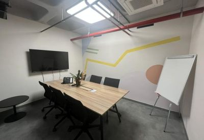Small meeting room with a wooden table, wall graphics, and a whiteboard.