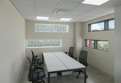Compact private office room with two workstations and horizontal windows.