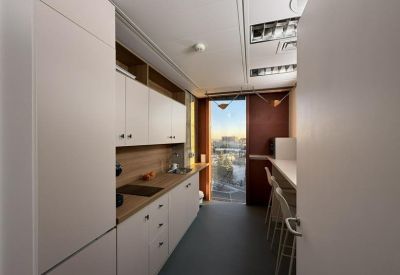 Modern galley kitchen with light wood countertops and white cabinetry.