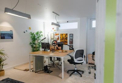 Private office suite featuring a desk, ergonomic chair, and decorative wall plants.