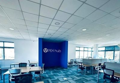 Spacious open-plan office with grey workstations and a blue central feature wall.