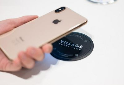 Close-up of a smartphone utilizing a wireless charging pad on a desk.