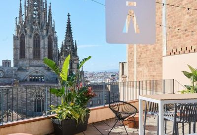 Rooftop deck featuring high tables and a clear view of a cathedral spire.