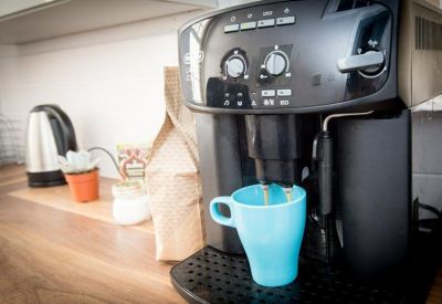 Communal kitchen area with a modern coffee machine and a light blue mug.