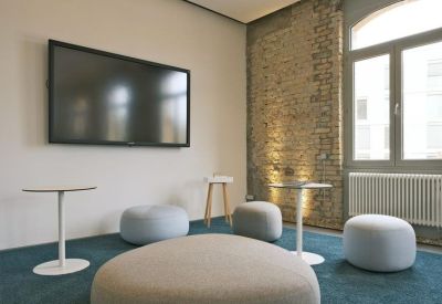 Bright breakout space featuring a feature brick wall and a variety of seating options.