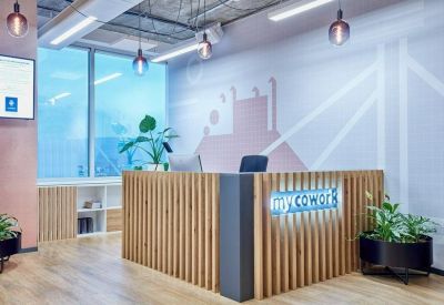 Branded reception area with a slatted wood desk and soft blue accent lighting.