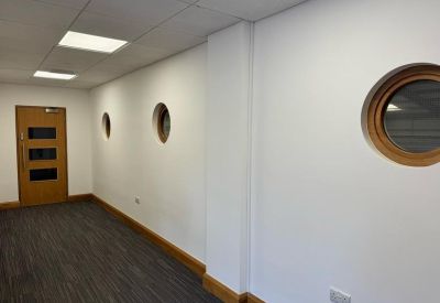 Bright hallway with white walls and distinctive circular porthole windows.