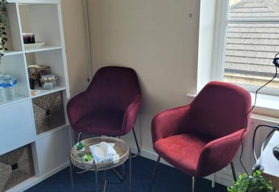Breakout area with two velvet armchairs and a small side table.