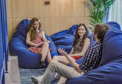 Informal breakout area with blue bean bag chairs and wooden wall panels.