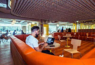 Spacious lounge with orange leather banquette seating and a textured ceiling.