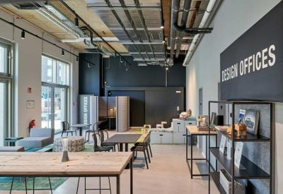 Reception area with wooden tables and a large black sign for Design Offices.