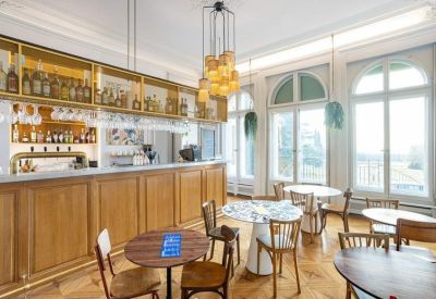 Elegant café and bar area with wooden counters and modern light fixtures.