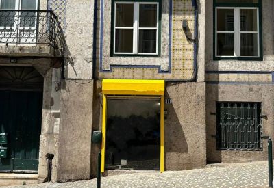 Exterior facade of a traditional tiled building featuring a distinctive yellow-framed ground floor entrance.