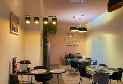 Social area with round dining tables, black chairs, and modern pendant lighting.