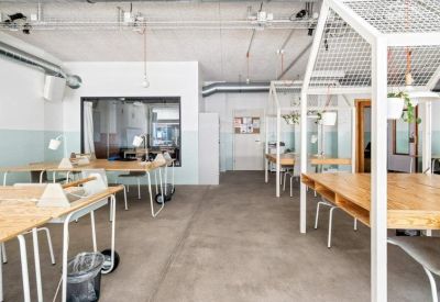 Open-plan coworking office featuring house-shaped wooden desk frames.