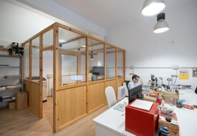 View from an open workspace looking towards a glass-partitioned meeting area.