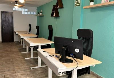 Open-plan workspace at Nexus 38 Multispace featuring standing desks and teal accent walls.