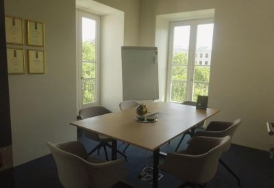 Bright four-person meeting room with large windows and a whiteboard.
