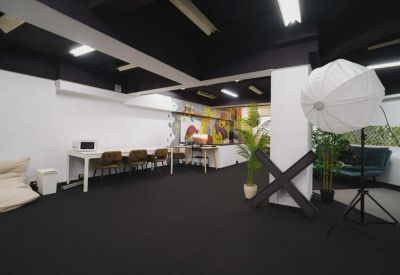 Spacious multi-use workspace at 1, Rua Casimiro Freire featuring photography lighting and communal tables.