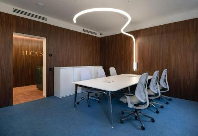 Private meeting room with wood-paneled walls and modern grey ergonomic chairs.