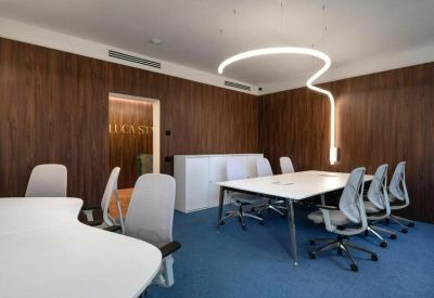 Bright meeting space with a white desk, blue flooring, and artistic overhead light fixtures.