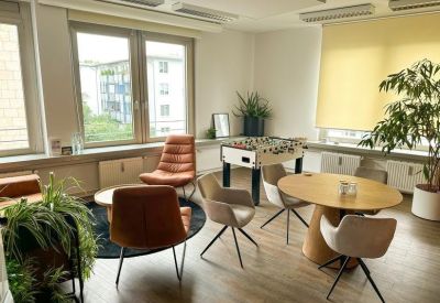 Casual breakout room featuring a foosball table, potted plants, and comfortable lounge seating.