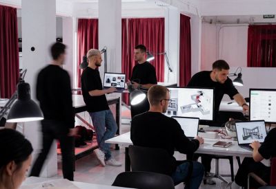 High-ceiling open-plan workspace with white columns and deep red drapes.