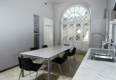 Communal kitchen and dining area with a marble countertop and arched glass doors.