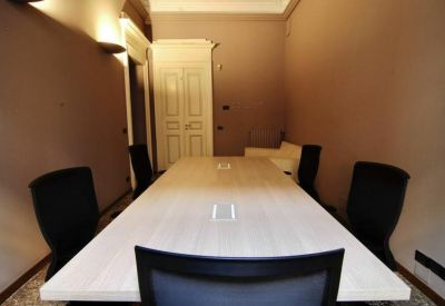 Meeting room with a long white table and warm wall lighting.