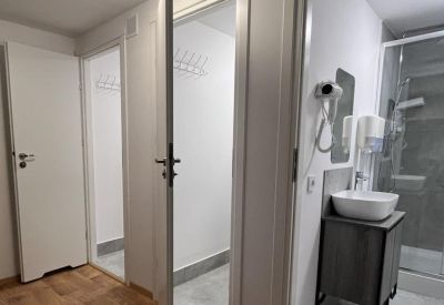 Hallway leading to modern private shower rooms and changing areas.