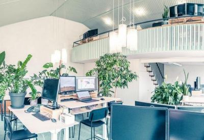 Modern multi-level workspace with a sleek staircase and hanging pendant lights.