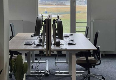 Bright workspace with dual desks and large windows overlooking the countryside.