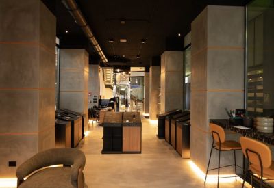Main reception hallway showcasing industrial concrete pillars and warm integrated floor lighting.