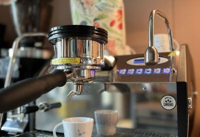 Close-up of a professional espresso machine and coffee cups in a kitchen area.