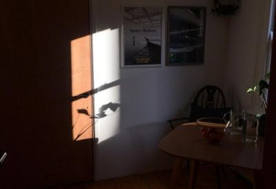 Quiet seating area with a small wooden table illuminated by dramatic natural sunlight.
