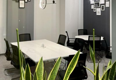 Well-lit meeting room with white tables and framed wall decor.