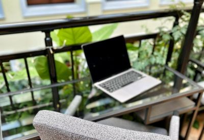 Compact workstation area with a glass desk and a comfortable grey chair.